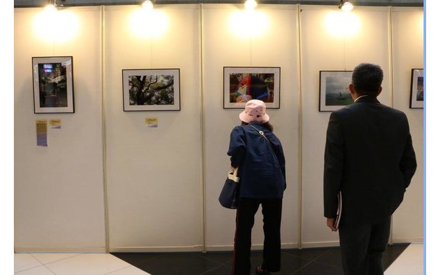  攝影展的開幕/ Inauguration de l'exposition dans le Hall de la Gare centrale de Taipei. Des visiteurs regardent de plus près les photographies de Sarah Vandy – à Taïwan.